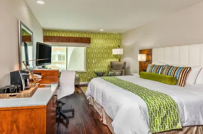 a hotel room with a bed and a desk with a computer at Hotel Indigo Anaheim by IHG in Anaheim