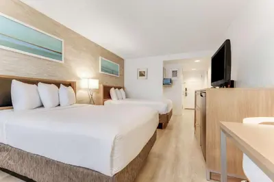 a hotel room with two beds and a flat screen tv at Sonesta Anaheim Resort Area in Anaheim