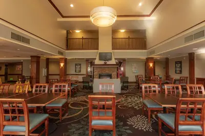 a large room with tables and chairs and a fireplace at Sonesta ES Suites Anaheim Resort Area in Anaheim