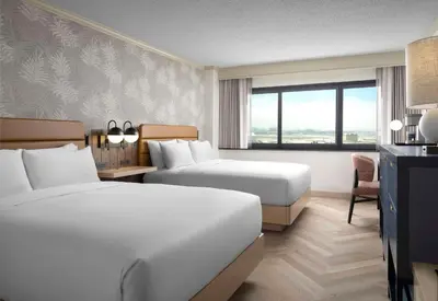 a hotel room with two beds and a window at Sonesta Los Angeles Airport LAX in Los Angeles