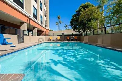 a swimming pool at a hotel with a building at Holiday Inn Express Los Angeles LAX Airport by IHG in Los Angeles