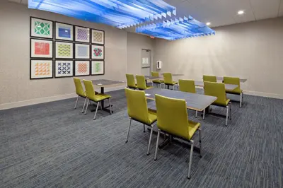a conference room with tables and yellow chairs at Holiday Inn Express Los Angeles LAX Airport by IHG in Los Angeles