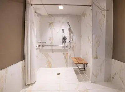 a bathroom with a shower with a bench in it at Beverly Hills Marriott in Los Angeles