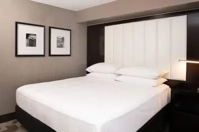 a bedroom with a large bed with white pillows at Beverly Hills Marriott in Los Angeles
