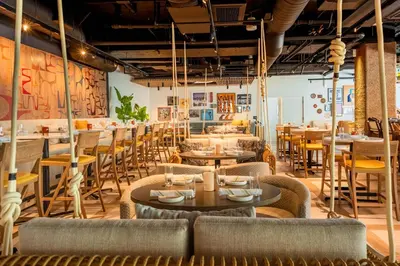 a restaurant with tables and chairs and a bar at The Pierside Santa Monica in Los Angeles