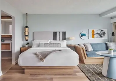 a bedroom with a large bed and a blue couch at The Pierside Santa Monica in Los Angeles