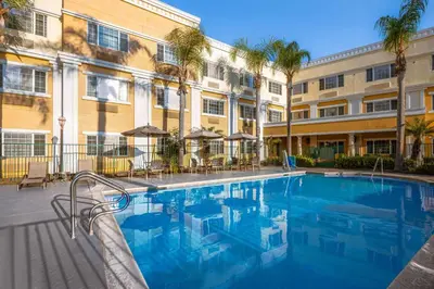 a large swimming pool in front of a building at Hotel Marguerite South Anaheim - Garden Grove, Trademark Collection by Wyndham in Anaheim