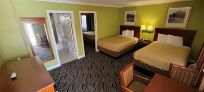 a hotel room with two beds and a mirror at Redondo Inn and Suites in Redondo Beach