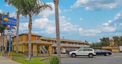 a parking lot with cars parked in front of a hotel at Redondo Inn and Suites in Redondo Beach