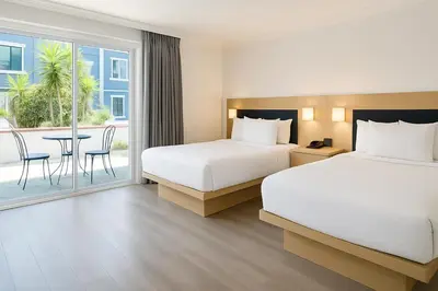 a hotel room with two beds and a table at The Live Hotel in Los Angeles