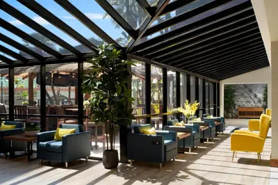 a lobby with chairs and tables and windows at Four Points by Sheraton Anaheim in Anaheim