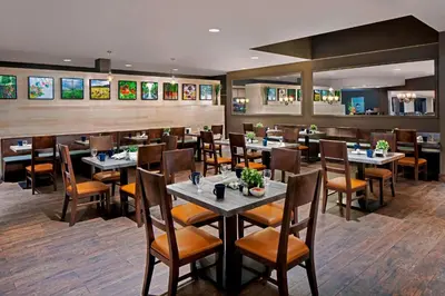a dining room with tables and chairs in a restaurant at Four Points by Sheraton Anaheim in Anaheim