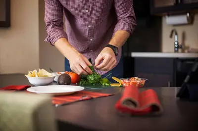 a man preparing food on a counter in a kitchen at Sonesta Simply Suites Anaheim in Anaheim