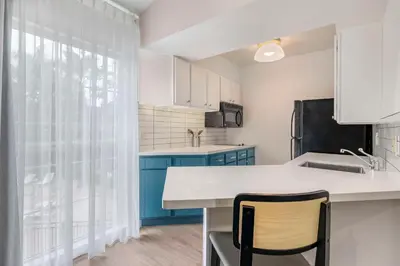 a kitchen with a sink and a counter with a chair at Sonesta ES Suites Torrance Redondo Beach in Torrance