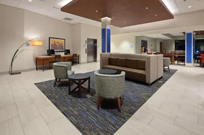 a lobby with a couch and chairs and a table at Holiday Inn Express Hotel & Suites Ventura Harbor by IHG in Ventura
