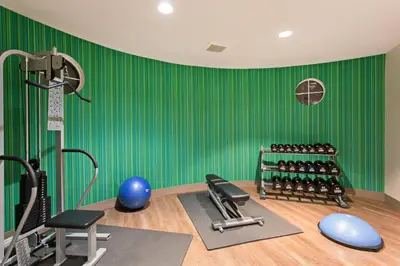 a gym with green walls and exercise equipment at Holiday Inn Express & Suites Corona by IHG in Corona