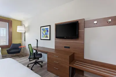 a hotel room with a desk and a flat screen tv at Holiday Inn Express & Suites Corona by IHG in Corona