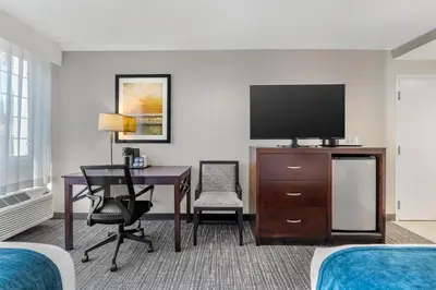 a hotel room with a desk and a flat screen tv at Best Western Plus Carriage Inn in Sherman Oaks