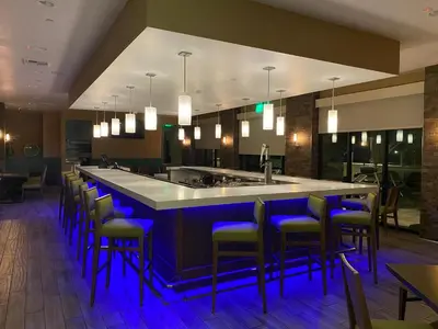 a bar in a restaurant with blue bar stools at Holiday Inn Diamond Bar - Pomona by IHG in Diamond Bar
