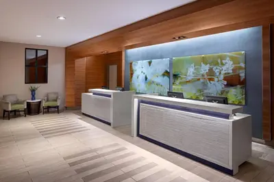 a lobby with reception desks and a large painting on the wall at Delta Hotels by Marriott Anaheim Garden Grove in Anaheim