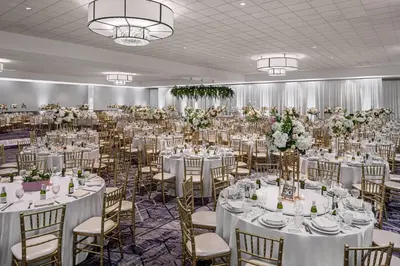 a banquet hall with white tables and chairs and flowers at Delta Hotels by Marriott Anaheim Garden Grove in Anaheim