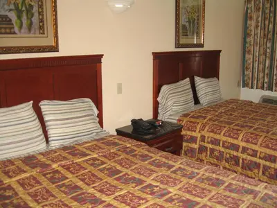 a hotel room with two beds and a phone on a table at Royal Inn Motel Long Beach in Long Beach