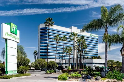 an office building with palm trees in front of it at Holiday Inn Los Angeles Gateway-Torrance by IHG in Torrance