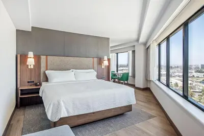 a bedroom with a large bed and large windows at Holiday Inn Los Angeles Gateway-Torrance by IHG in Torrance
