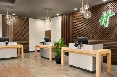 a lobby with three desks with laptops on them at Holiday Inn Los Angeles Gateway-Torrance by IHG in Torrance