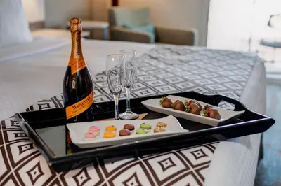 a tray with a bottle of champagne and plates of food at Crowne Plaza Ventura Beach by IHG in Ventura