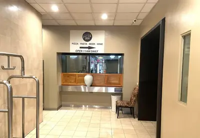 a lobby with a waiting room with a vase on the wall at Ramada by Wyndham Los Angeles/Wilshire Center in Los Angeles
