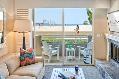 a living room with a fireplace and a view of the beach at Beach House Hotel at Hermosa Beach in Hermosa Beach