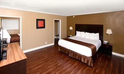 a hotel room with a large bed and a bathroom at Americas Best Value Inn & Suites Anaheim in Anaheim