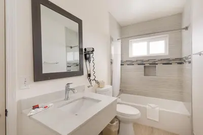 a bathroom with a sink and a toilet and a mirror at Americas Best Value Inn & Suites Anaheim in Anaheim