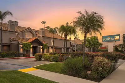 a villa with palm trees and a street sign at Sonesta ES Suites Chatsworth in Chatsworth