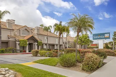 a villa with palm trees and a sign at Sonesta ES Suites Chatsworth in Chatsworth