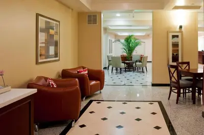 a lobby of a hotel with chairs and a table at Holiday Inn Express Hotel & Suites Los Angeles Airport Hawthorne by IHG in Hawthorne