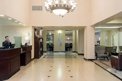 a man standing at a counter in a lobby at Holiday Inn Express Hotel & Suites Los Angeles Airport Hawthorne by IHG in Hawthorne