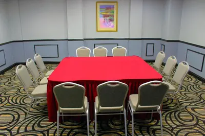 a conference room with a red table and chairs at Holiday Inn Express Van Nuys by IHG in Van Nuys