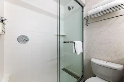 a bathroom with a glass shower door next to a toilet at Holiday Inn Express Van Nuys by IHG in Van Nuys