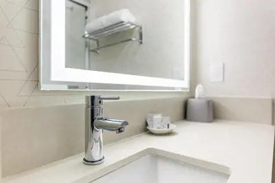 a bathroom with a sink and a mirror at Holiday Inn Express Van Nuys by IHG in Van Nuys