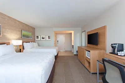 a hotel room with two beds and a flat screen tv at Holiday Inn Palmdale-Lancaster by IHG in Palmdale