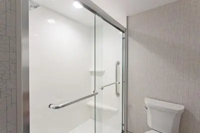 a glass shower door in a bathroom with a toilet at Holiday Inn Express & Suites Pasadena - Los Angeles by IHG in Pasadena