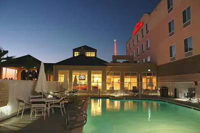 a hotel with a swimming pool in front of a building at Hilton Garden Inn Victorville in Victorville