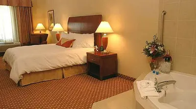 a hotel room with a bed and a bath tub at Hilton Garden Inn Victorville in Victorville