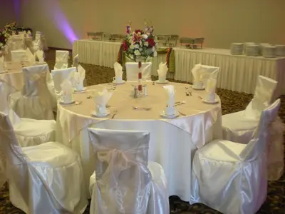 a table with white tables and chairs in a room at Hilton Garden Inn Victorville in Victorville