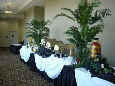 a row of tables in a room with palm trees at Hilton Garden Inn Victorville in Victorville