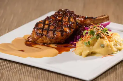 a plate of food with meat and potatoes on a table at DoubleTree by Hilton Carson in Carson