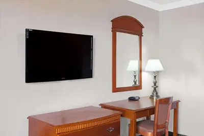 a room with a desk and a television on the wall at Super 8 by Wyndham Hollywood/LA Area in Los Angeles