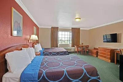a hotel room with a bed and a desk at Super 8 by Wyndham Hollywood/LA Area in Los Angeles